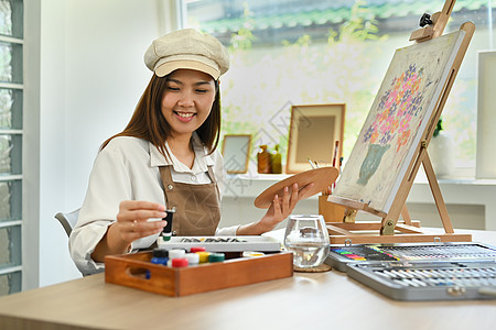 漂亮的年轻女人用水彩创作艺术品 在家里享受创意活动 艺术休闲活动理念图片