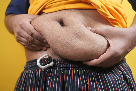 男人的手握着过量的肚子脂肪 超重的概念数字营养矫正腹部肥胖身体男性皮肤成人疾病图片
