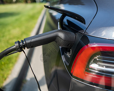 黑色电动汽车在夏季向户外充电生态旅行技术机动性排放燃料车站引擎能源电缆图片