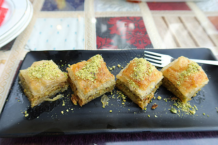 一个盘子上的阿拉伯甜甜点糕点金子坚果小吃糖浆文化榛子棕色食物美食图片