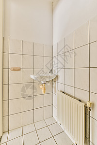 一个小浴室 有水槽和散热器淋浴龙头地面浴缸卫生瓷砖建筑学公寓风格酒店图片
