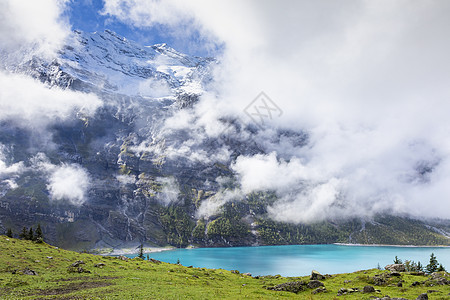 在瑞士伯尔尼斯奥伯兰高山的奥斯金森西 Oeschinen湖全景旅游地方山脉表面高地雪山湖岸松树目的地图片