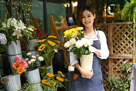 站在花店前手持美丽花束的华丽女花店画像图片