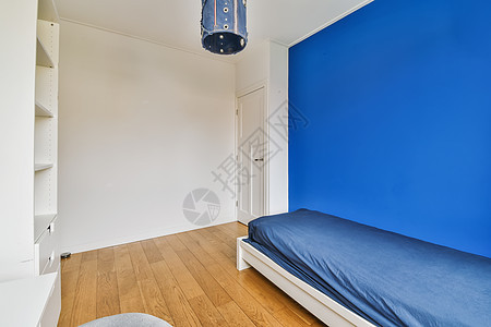 一张床和蓝色口音墙的卧室房间奢华酒店家具公寓窗户木头房子建筑学装饰图片