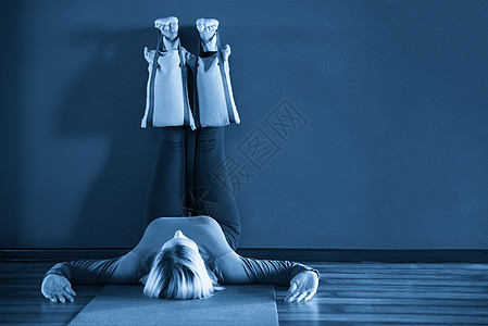 做瑜伽的年轻女青年 用双腿对着墙 用沉重的沙袋来放松姿势红色女士训练活动工作室女性蓝色运动身体女孩图片