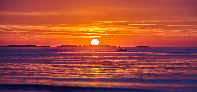 东海岸海洋的金光 日出和远处太阳和渔船的详细细节;以及图片