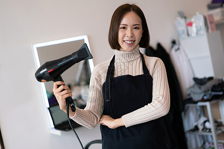 一个年轻的亚洲女理发师的肖像 拥有合格的理发工具美容师女士造型师梳妆台剪刀商业照片企业家店铺职业图片