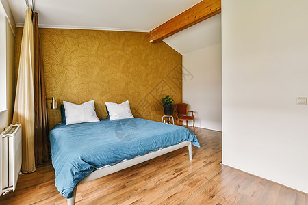 一间有床和木地板的卧室地面房子控制板枕头地毯墙壁旅馆风格装饰沙发背景图片