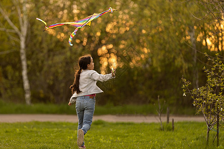 带着风筝跑在草地上的快乐女婴乐趣微笑场地活动运动晴天幸福头发彩虹女孩图片