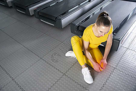 身穿运动服的年轻女性在健身房训练时膝盖疼痛 女孩坐在地板上痛苦地触摸膝盖运动员体育锻炼运动肌肉事故地面伤害身体女士成人图片