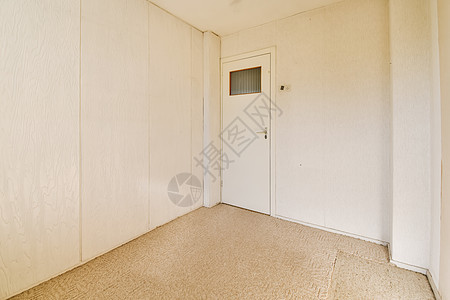 一个有白墙和一扇门的房间装饰家具桌子财产卧室公寓地下室风格奢华地毯背景图片