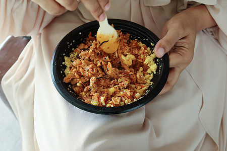 妇女吃咖喱鸡和大米 拿掉塑料袋图片