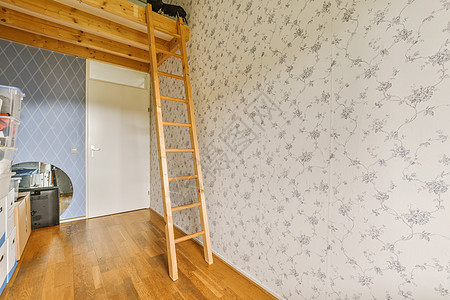 a 梯子对着墙壁 在一个带有壁纸的房间里图片