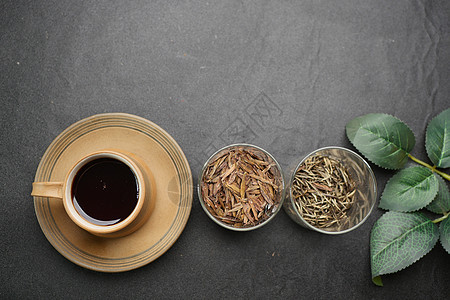 茶壶里的干茶叶和桌上的茶杯图片