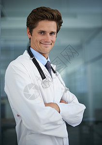 他有一个很棒的床边行为方式 一个英俊年轻医生的肖像 脖子上戴着一个听诊器 在镜头前微笑图片