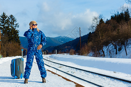 女人在雪地火车站拖着重型行李 冬天乘火车旅行雪花保暖火车站乘客压力降雪城市车站季节铁路图片