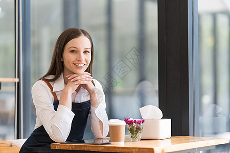 坐在咖啡店柜台的快乐小商家肖像 亚裔女律师协会成员穿着围裙 在咖啡馆酒吧微笑 食品服务 餐厅概念咖啡师工作经理员工企业家笔记本桌图片