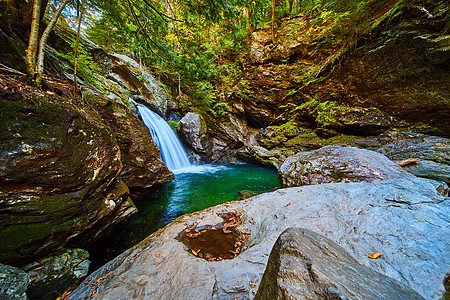 美丽的蓝水从瀑布上漂浮在悬崖边 四周环绕着巨石图片