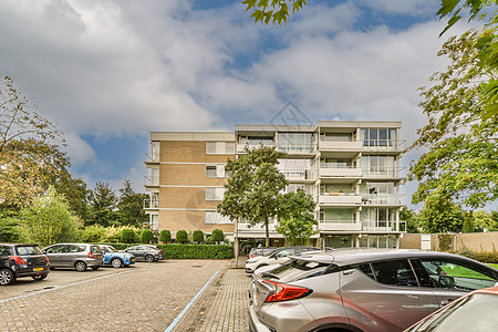 一幢公寓楼 前面停有汽车的汽车建筑玻璃办公室建筑物旅行财产大学车辆住房建筑学背景图片