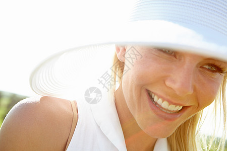 一位快乐的年轻女子 在田野中穿着大晒太阳衣 -图片