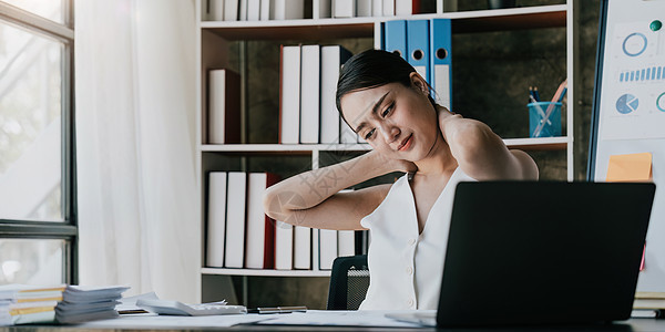 女商务人士在笔记本电脑上过度工作 在办公室工作时颈部疼痛 女孩压力和长期患有办公室综合症的疾病 健康和情感概念肌肉痛苦肩膀过滤症图片