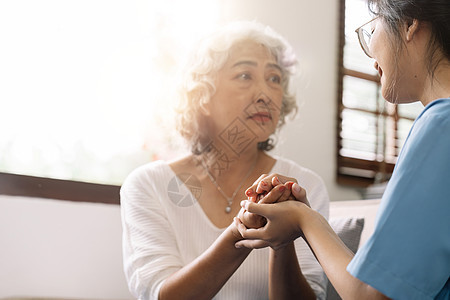 快乐的病人在共度时间时 会牵着照顾者的手 老年妇女在疗养院和护士室工作护理职业帮助女性成人服务医院男人卫生微笑图片