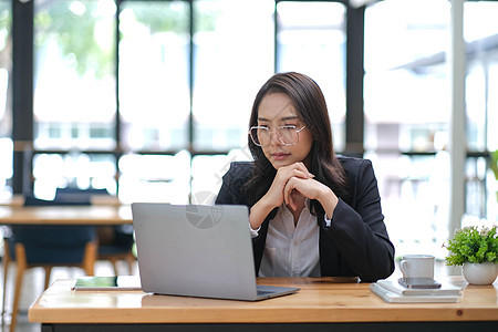 专业的亚洲女商务人士或女经理正在沉思地考虑她在办公室的项目的商业计划或商业问题解决方案桌子人士办公桌电脑商务经理职场精神女性思维图片