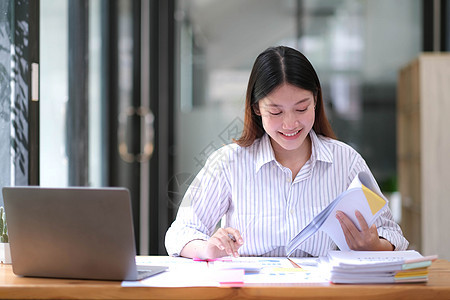 办公室的亚洲漂亮女性 计算员 在商业工作空间桌子上做数据 图表和文件的工作图片