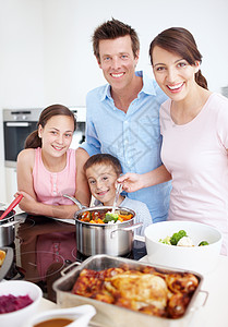 妈妈的饭菜每个人都尽自己的一份力量来做一顿美餐 一个高兴的家庭在厨房里一起做一顿丰盛可口的饭菜的肖像背景