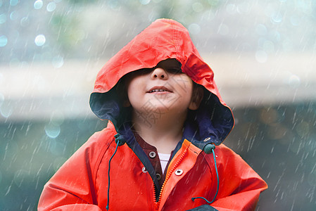 如果你觉得天气凉爽 就来看我 有个可爱的小男孩在雨中在外面玩耍图片