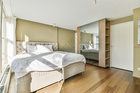带有最起码风格家具的床房房间财产窗户日光壁橱住宅公寓住宿椅子毯子图片