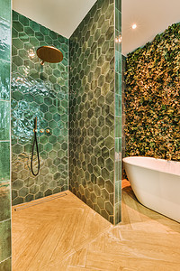 一个配绿色瓷砖 浴缸和淋浴的浴室图片