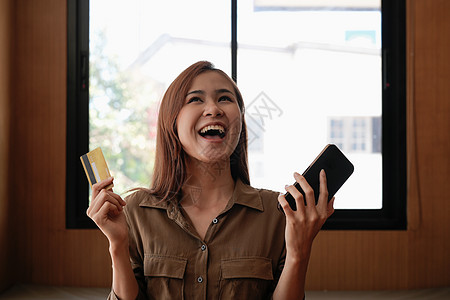 兴奋的女性持有信用卡 使用手机 网上购物黑色周五 请访问InfoFlickr用户网站商业电话购物客户金融借方银行银行业男人电脑图片