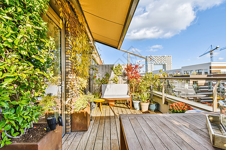 一个阳台 配有木制地板和木制植物以及一张桌子图片