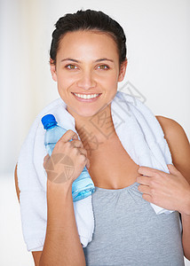 一个穿着体操服的年轻女子 和一瓶水的肖像 我用瓶装水来做运动图片