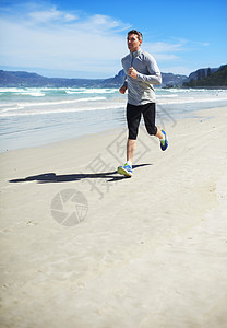 健壮的狂热分子 一个男人在沙滩上慢跑训练成人男性运动慢跑者海滩海洋运动装运动服赛跑者图片