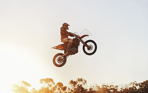 从空中飞过 在比赛中 骑摩托的车手在半空拍到的一张照片图片