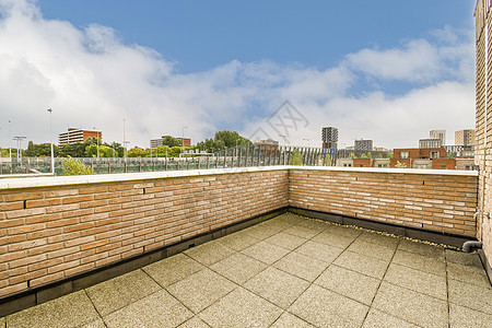 一个有砖墙和城市天线的阳台图片