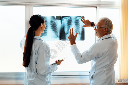 两名医生检查了在消毒室进行医疗X光诊断的射线图x光胸片医学疾病专家x射线电影医院咨询诊所图片