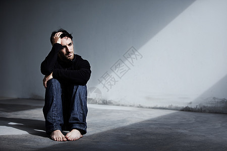 他最近患有抑郁症 一个年轻人坐在地上 手放在头上图片