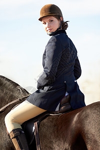 年轻女骑手的肖像 她骑着马搭上一个年轻的女骑兵图片