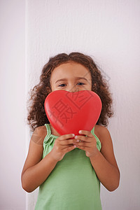 如果我给你我的心脏 请不要打破它 一个年轻女孩笑着看着她拿着一个心形玩具图片