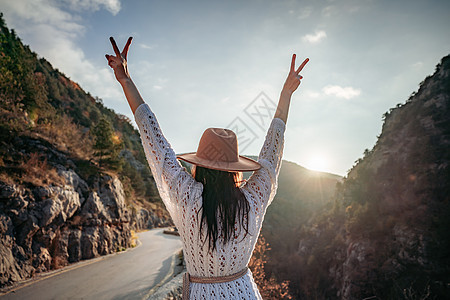 穿着棕帽子和白色毛衣的女旅行者 看着惊人的山峰和森林 漫游概念 大气史诗时刻自由流浪者远足者假期晴天远足探索背包女性冒险图片