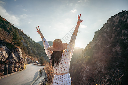 穿着棕帽子和白色毛衣的女旅行者 看着惊人的山峰和森林 漫游概念 大气史诗时刻游客女孩旅行假期探索远足远足者自由冒险树木图片