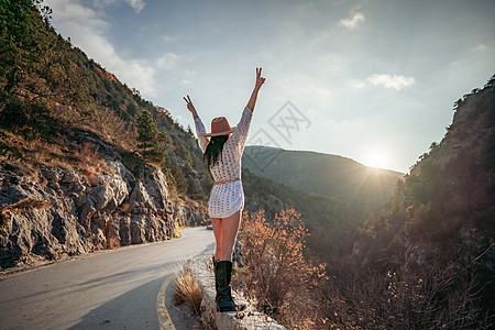 穿着棕帽子和白色毛衣的女旅行者 看着惊人的山峰和森林 漫游概念 大气史诗时刻潮人山脉假期树木背包游客旅行探索远足者远足图片