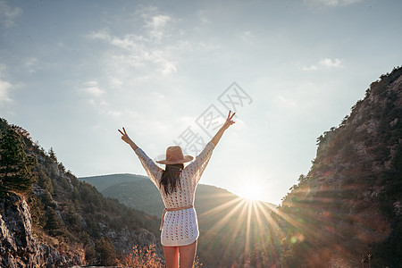 穿着棕帽子和白色毛衣的女旅行者 看着惊人的山峰和森林 漫游概念 大气史诗时刻树木背包山脉女孩晴天游客远足者荒野冒险流浪者图片