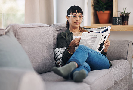 一位迷人的年轻女子独自坐在起居室看书 被拍到一整张照片 她读了一本书图片
