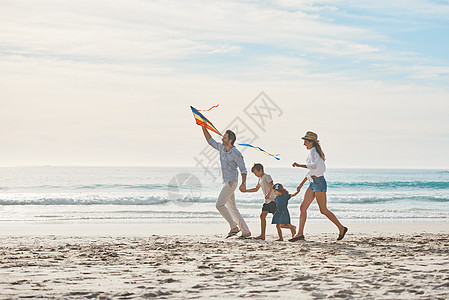 一对幸福的情侣带着孩子 带着风筝在海滩上走来走去 拍到一整条镜头 -你觉得它会消失吗?背景图片