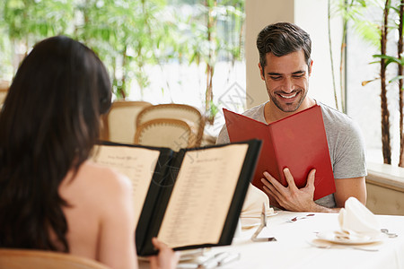 一对快乐的年轻夫妇在豪华餐厅 看着菜单 看菜谱的样子图片