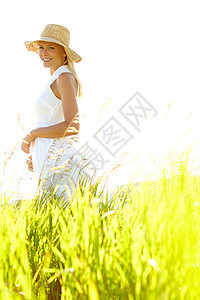乡下平静 一个迷人的金发年轻女人 夏天站在草地上晒日光浴图片